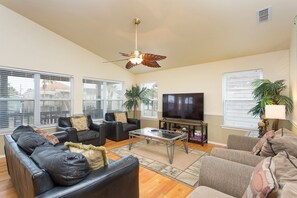Large open concept living room, with flat screen TV and access to the North facing balcony.