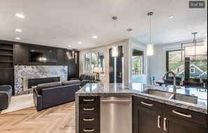 Open living room, dining room and kitchen with wonderful gas fireplace and patio