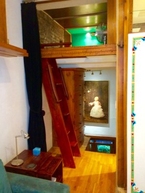 Another photo of loft and living space with entry stairs below.