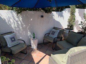 Sunken patio great for lounging under the sunbrella.