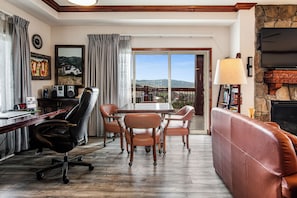 Left side living room with computer and game tables, seating, fireplace on right