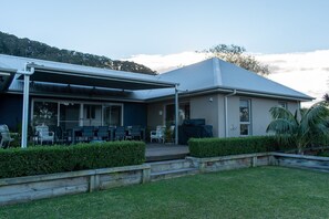 View of back of house and outdoor living area at dusk in winter