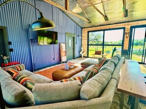 The glass-enclosed Solarium overlooks the pool w/ bar, mini fridge & TV. 