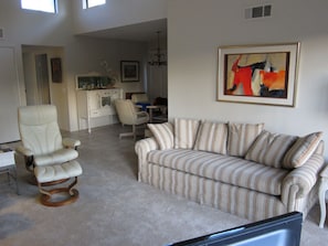 Clear story windows flood the living room with soft light