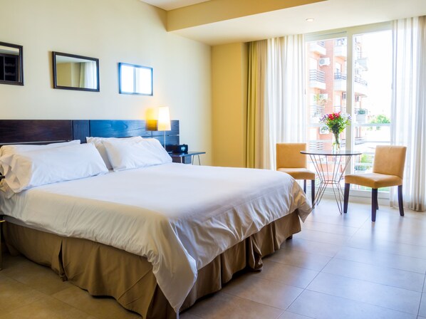 One of our pair of vacation studios in Buenos Aires, Argentina, with its king bed, dining table, and French-balcony window.