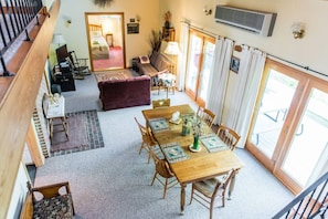 The open floor plan with dining area and living room is bright and sunny with two set of french doors leading to the deck.