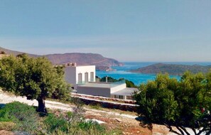 The two levels of the villa and its terraces, Spinalonga island behind.