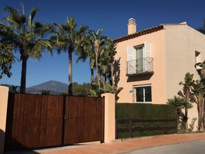 large gated garden over the full length of the house with 5 waving palmtrees