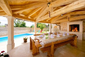 Dining area with the outdoor fireplace is just above the pool