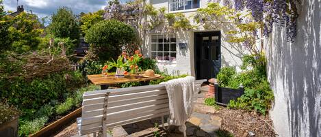 the patio and garden in front of the cottage