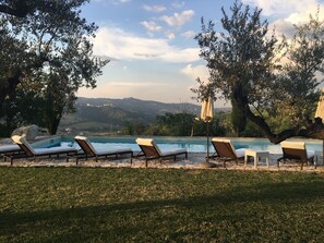 Setting sun by pool with view to hilltop town