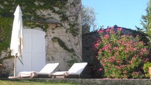 The terrace sun loungers and cottage behind