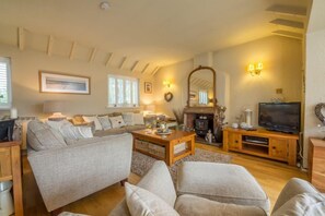 Ground floor: Sitting room with comfy sofas and electric wood burner