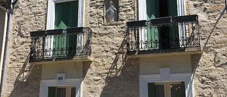 The front of the house with 2 balconies on the first floor.