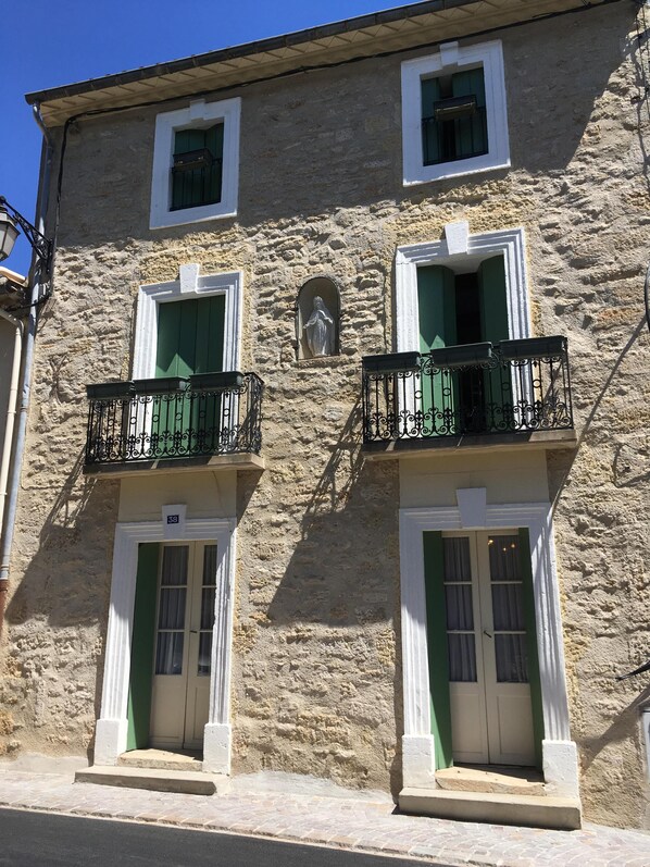 The front of the house with 2 balconies on the first floor.