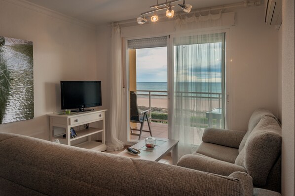 COMODAMENTE SENTADO EN EL APARTAMENTO Y VISTAS A LA PISCINA, PLAYA Y MAR