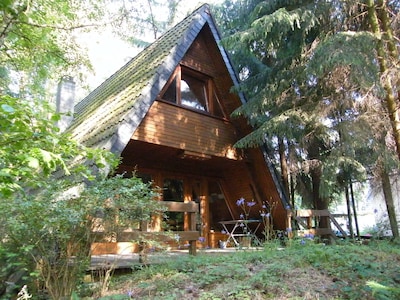 acogedora casa de madera en un idílico asentamiento de pinares con aguas de pesca cercanas.