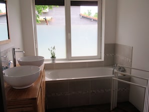 Comfotable bathroom with bath tube and separated shower. Closed toilets/WC.