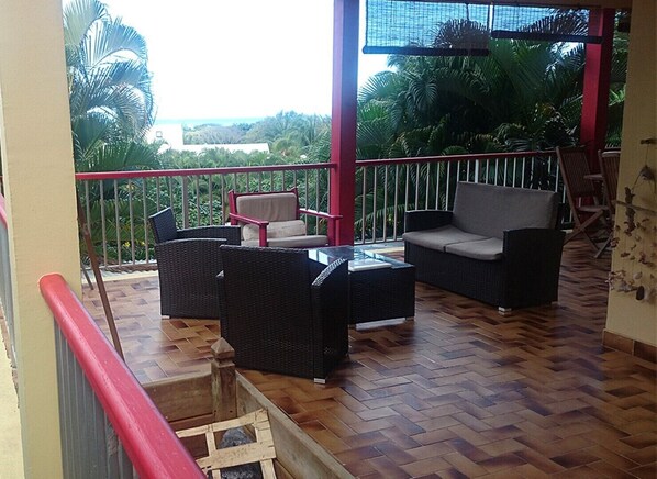 La partie salon de la terrasse. Au dessus de la végétation, la mer Caraibes.