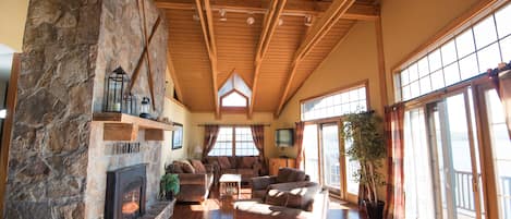 Livingroom with natural stone fireplace and panoramic views of the lake!