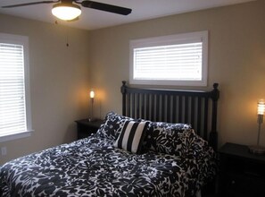 Queen Room with flat screen television, ceiling fan, and designer furnishings