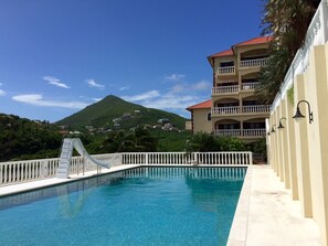 25 meter pool with a slide and a diving board. 