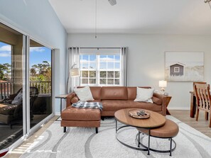 Leather sectional couch with power strips on both sides, window overlooks pool.