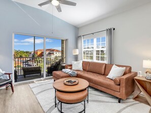Sectional leather couch, coffee table with seating, chair in corner, ceiling fan