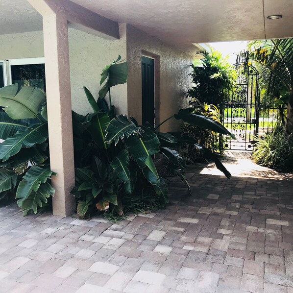 Tropical entrance through the gate to your own entrance.  Pool home!