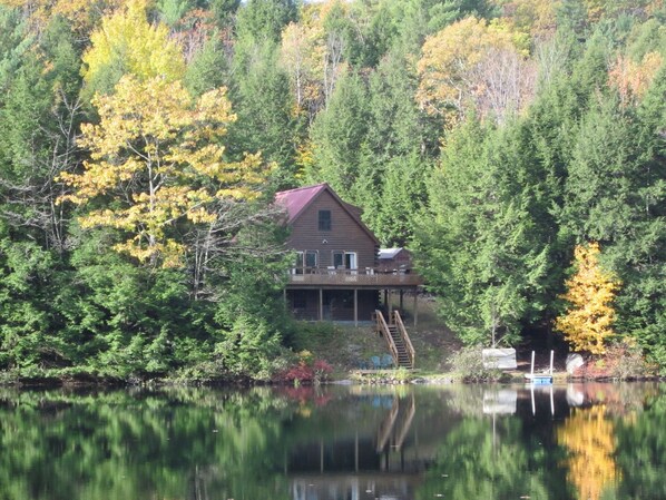 View of cabin from lake in October