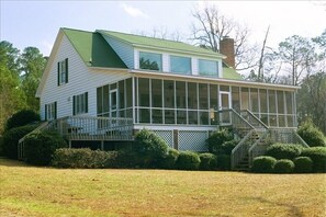 View of the back of the house and the large screen porch overlooking the lake.