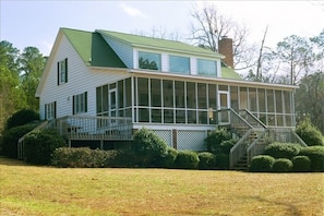 View of the back of the house and the large screen porch overlooking the lake.