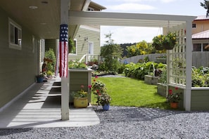 Entrance takes you past containers and hanging baskets of flowers and veggies.