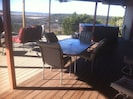 Covered deck with table, lots of seating and hot tub
