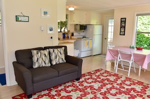 The living room flows into the well-equipped kitchen with a cozy dining area