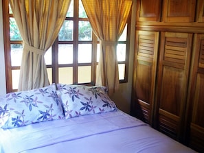 Guest cottage bedroom with queen bed and built-in closets.