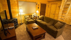 The living area has a loveseat and two chairs, perfect for game night!