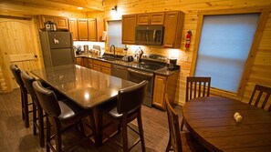 The kitchen features granite island and counters, and stainless appliances.