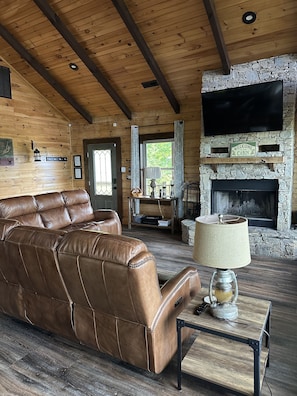 Living area with wood burning fireplace. 55 inch flat screen tv.