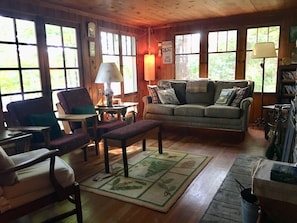 The cozy living room has a stone fireplace.