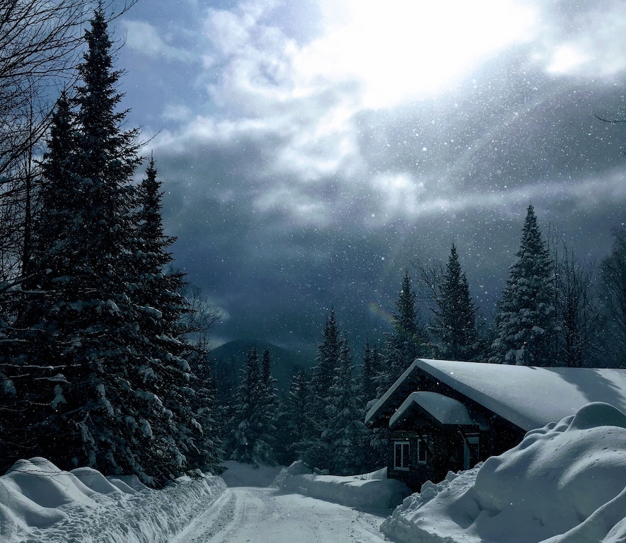 A romantic cottage in New Hampshire after a snow storm with snow piled high on the roads and roof