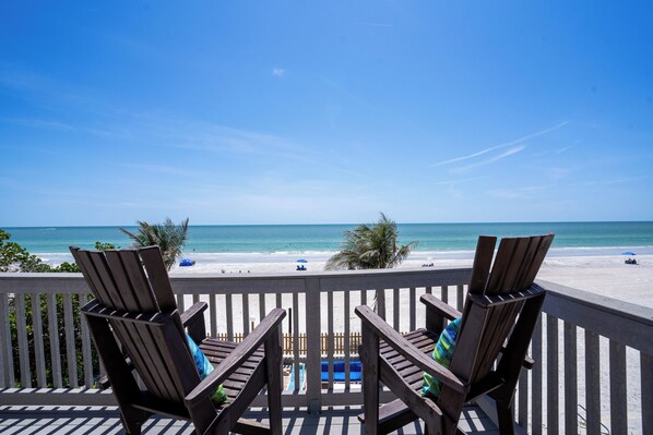 Large balcony set up with separate sitting areas with direct beach view