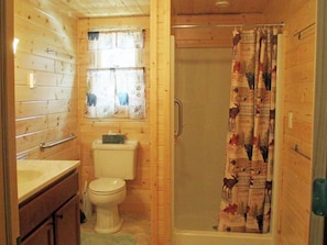 Large bathroom, vanity, high toilet, shower with grab bar, washer/dryer. 