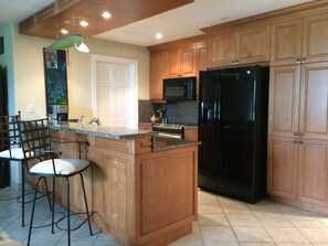 Spacious kitchen has full size appliances & ample cabinet/ pantry space