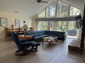 Large central great room offers comfortable seating, TV, and dining for 8