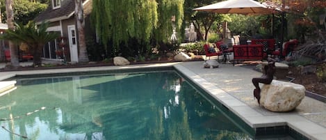 View of guest house as well as the side, rear garden and pool. 