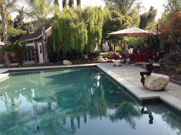 View of guest house as well as the side, rear garden and pool. 