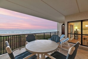 Spacious shaded balcony with comfortable furniture for dining & relaxing.