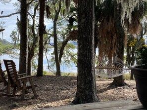 Waterfront backyard and deck with hammock and rockers.
