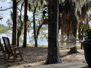 Waterfront backyard and deck with hammock and rockers.